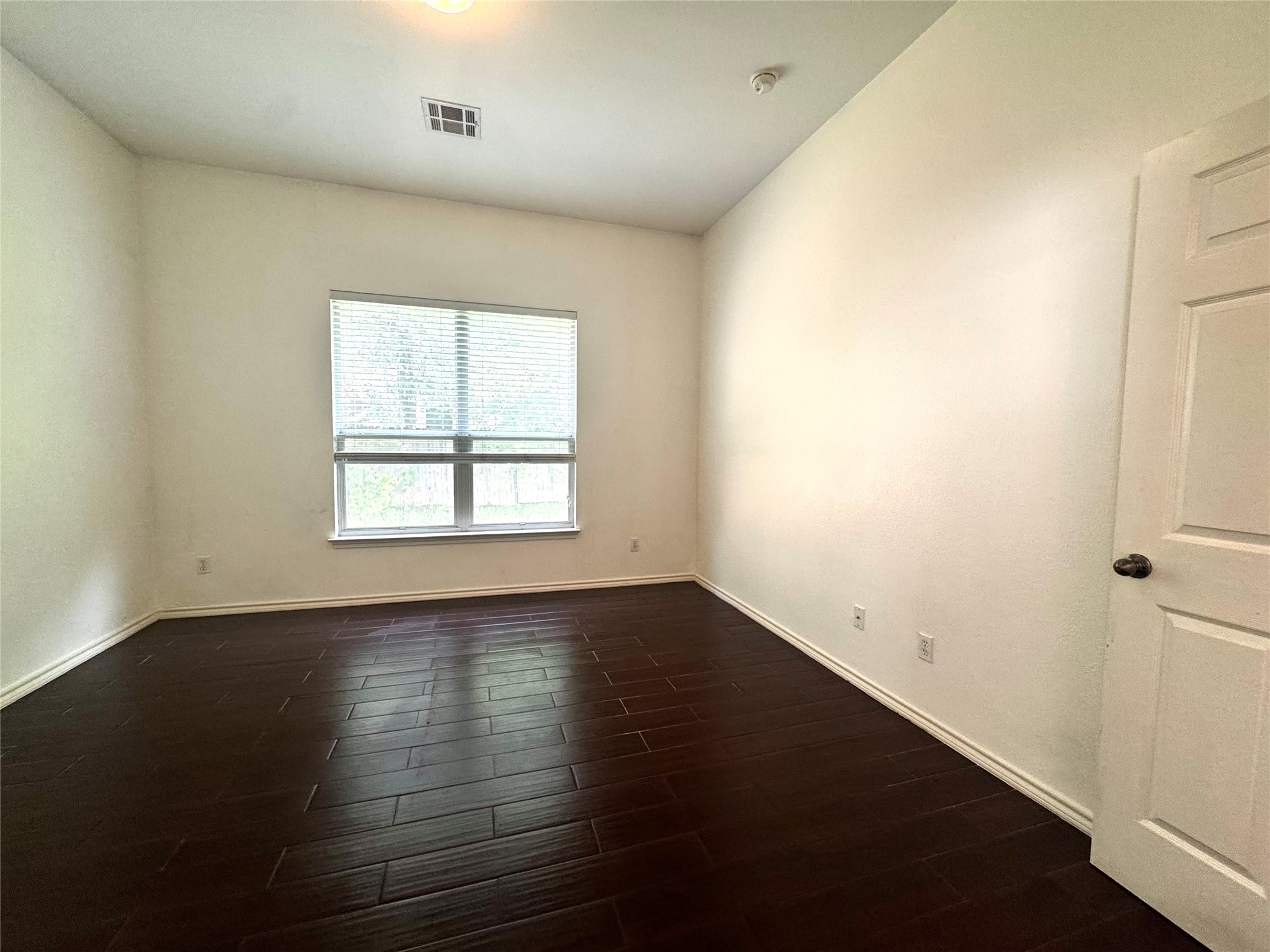 304 Valona Loop Round Rock, TX 78681 - Photo 10 of 15 Spacious room featuring dark wood-finish flooring, white baseboards, and a large window with blinds
