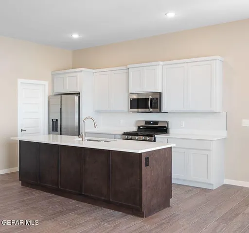 a kitchen with stainless steel appliances a sink stove and microwave