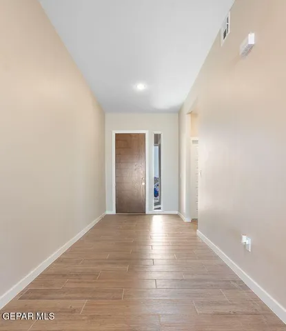 a view of a hallway with wooden floor