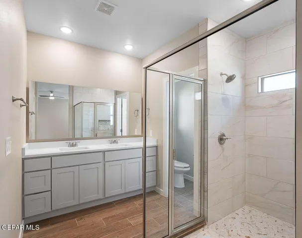 a bathroom with a double vanity sink mirror and shower