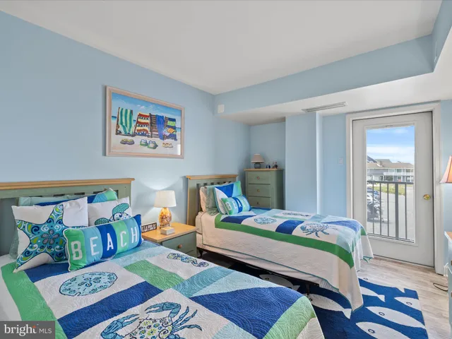 a bed room with a bed a couch and paintings on the wall