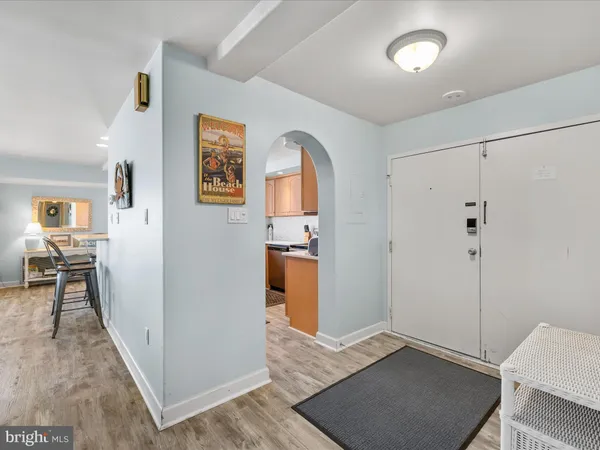 a view of a hallway with bathroom and wooden floor