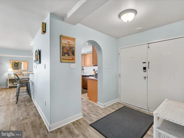 a view of a hallway with bathroom and wooden floor