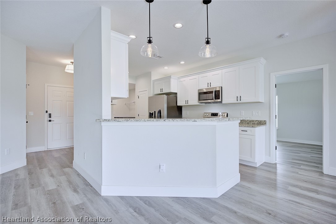 111 Vale Court Sebring, FL 33876 - Photo 10 of 40 a view of kitchen with stainless steel appliances granite countertop cabinets and wooden floor