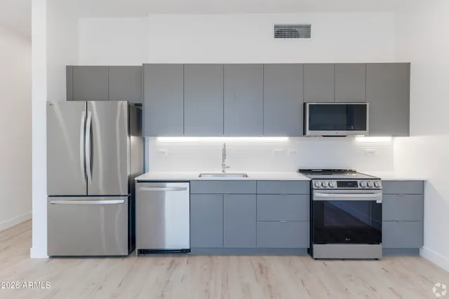 a kitchen with a stove refrigerator and microwave