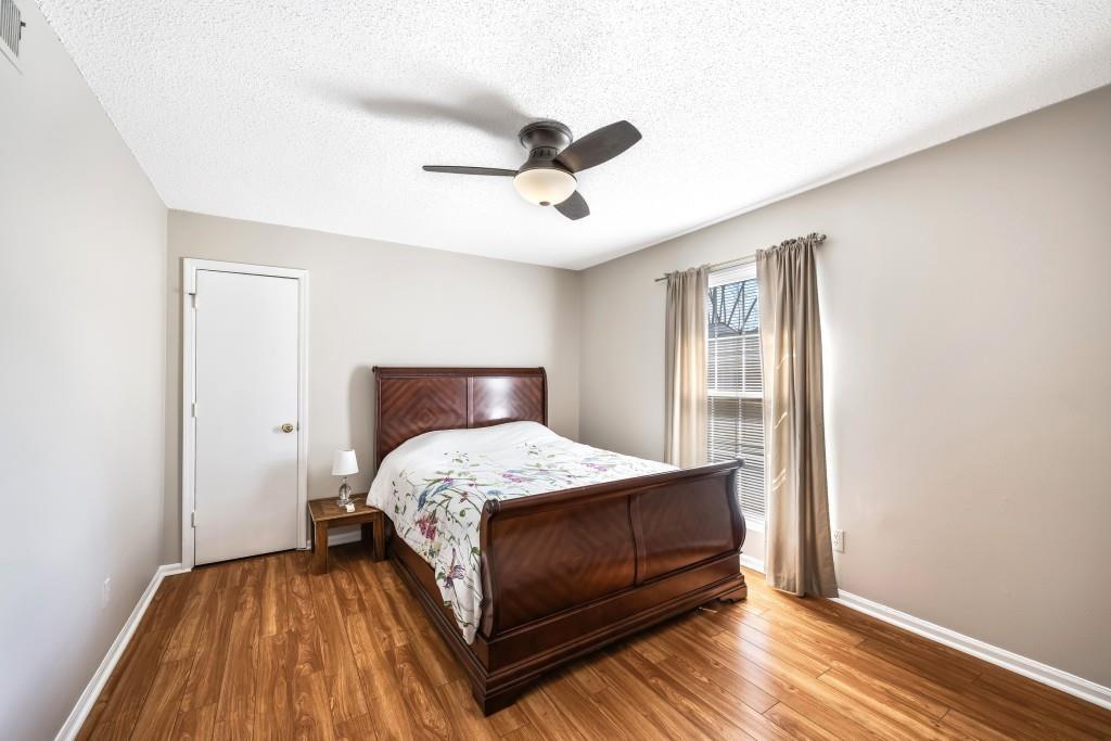 5629 Kingsport Drive, Unit 11 Atlanta, GA 30342 - Photo 20 of 52 a bedroom with a bed and wooden floor