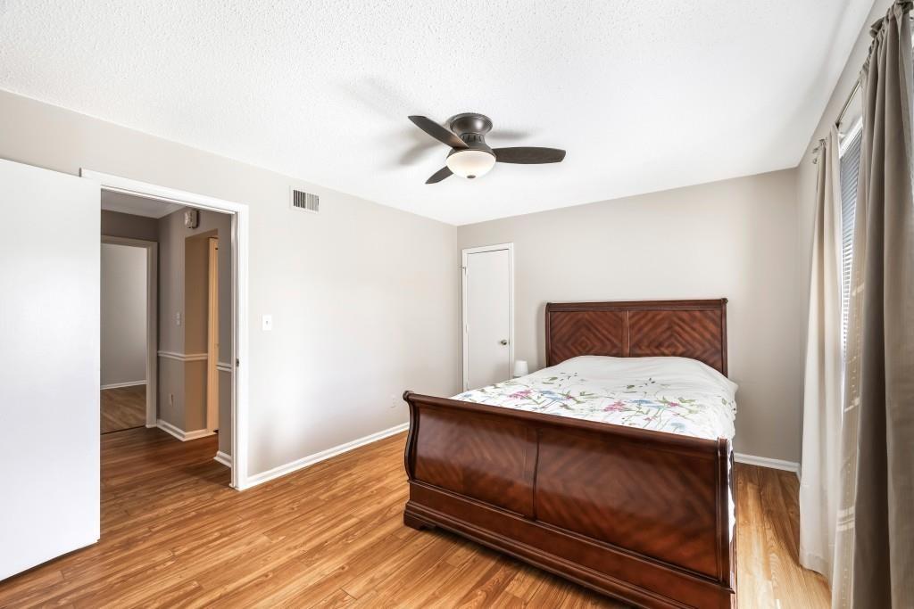 5629 Kingsport Drive, Unit 11 Atlanta, GA 30342 - Photo 21 of 52 a bedroom with a bed and wooden floor