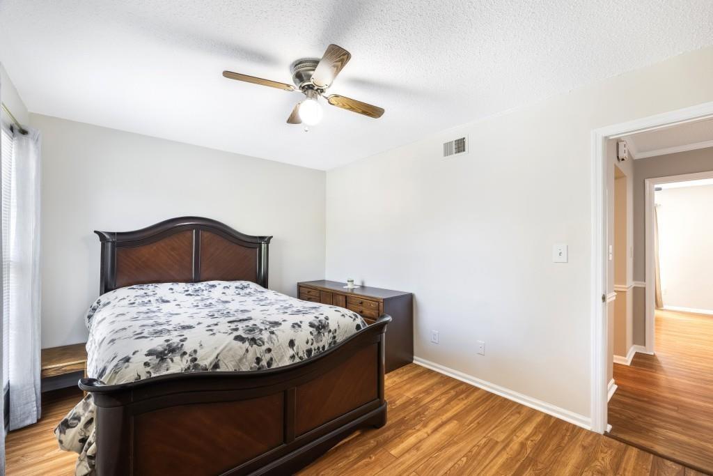 5629 Kingsport Drive, Unit 11 Atlanta, GA 30342 - Photo 23 of 52 a bedroom with a bed and wooden floor