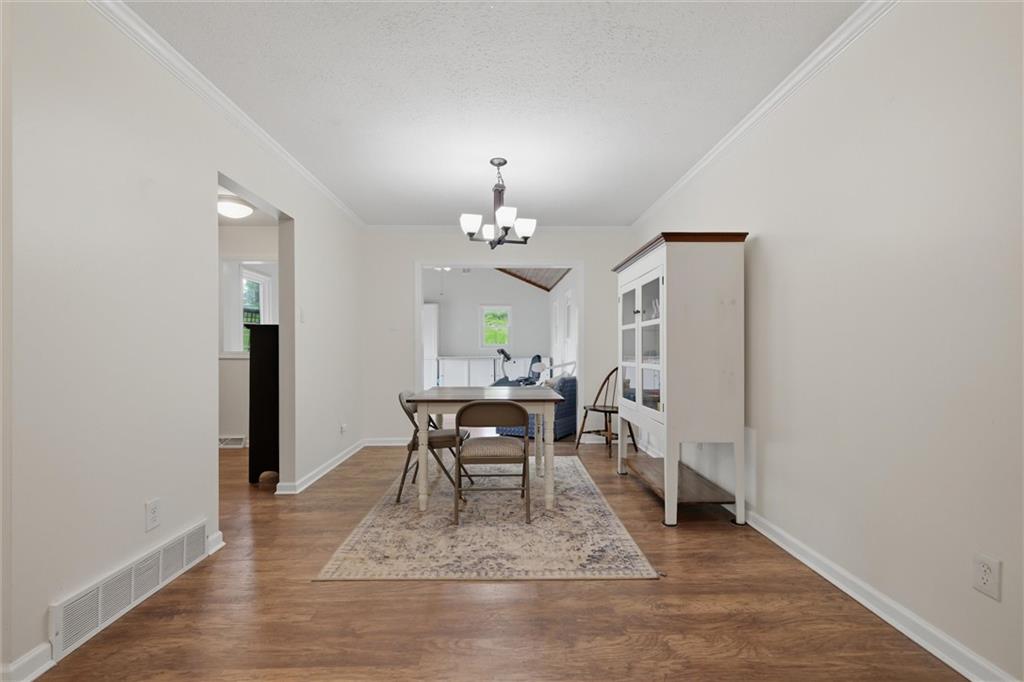 134 Stucky Road Renfrew, PA 16053 - Photo 5 of 32 a dining room with wooden floor a chandelier a wooden table and chairs
