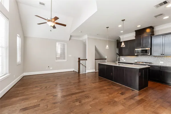 a large kitchen with stainless steel appliances kitchen island granite countertop a stove and a sink