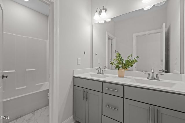 a bedroom with bed a mirror and a window