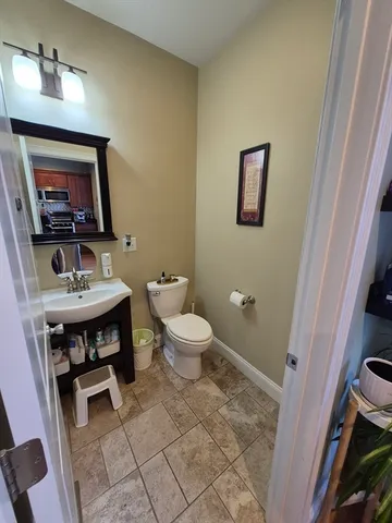a bathroom with a toilet a sink and mirror