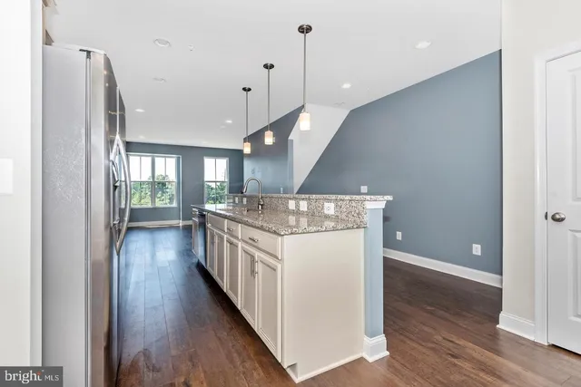 a kitchen with stainless steel appliances granite countertop a stove and a wooden floors