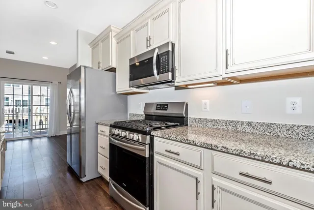 a kitchen with stainless steel appliances granite countertop a stove and a microwave
