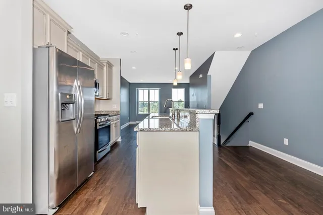 a view of a kitchen with refrigerator and wooden floor