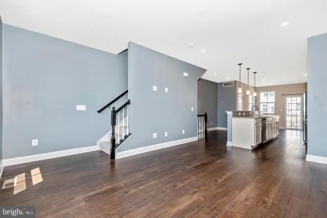 a view of a kitchen with wooden floor and a sink