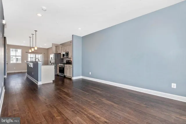 a view of a kitchen with a refrigerator and wooden floor