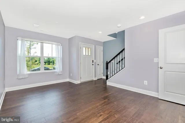 a view of an entryway with wooden floor windows and stairs