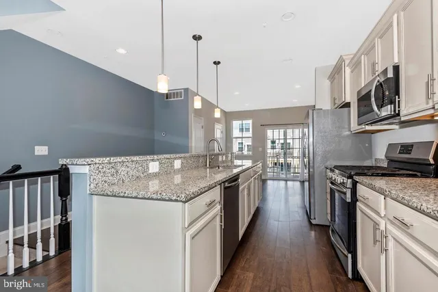 a kitchen with stainless steel appliances granite countertop a stove and a sink