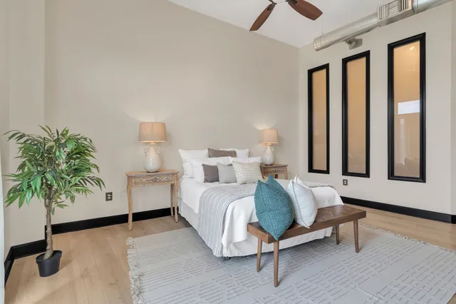 a spacious bedroom with a bed and a potted plant