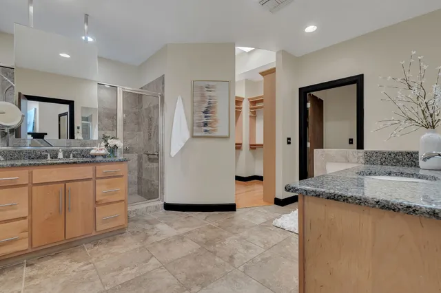 a spacious bathroom with a granite countertop sink and a mirror
