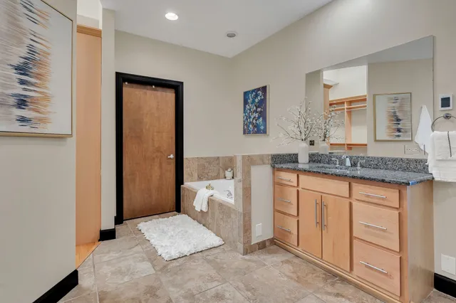 a spacious bathroom with a granite countertop sink and a mirror