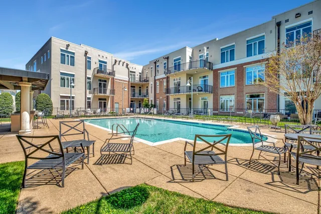 a view of a building with swimming pool and sitting area