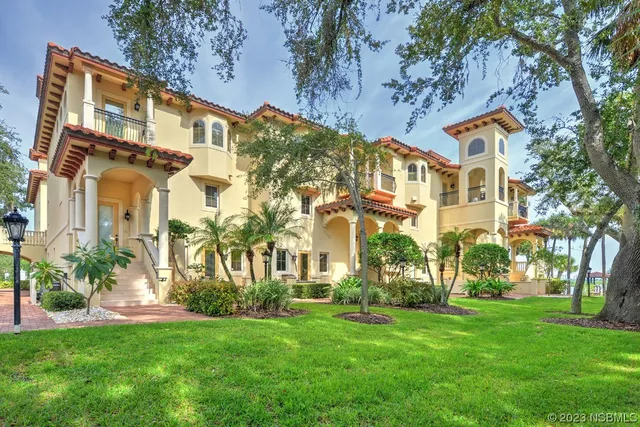 a view of a big building with a big yard and plants