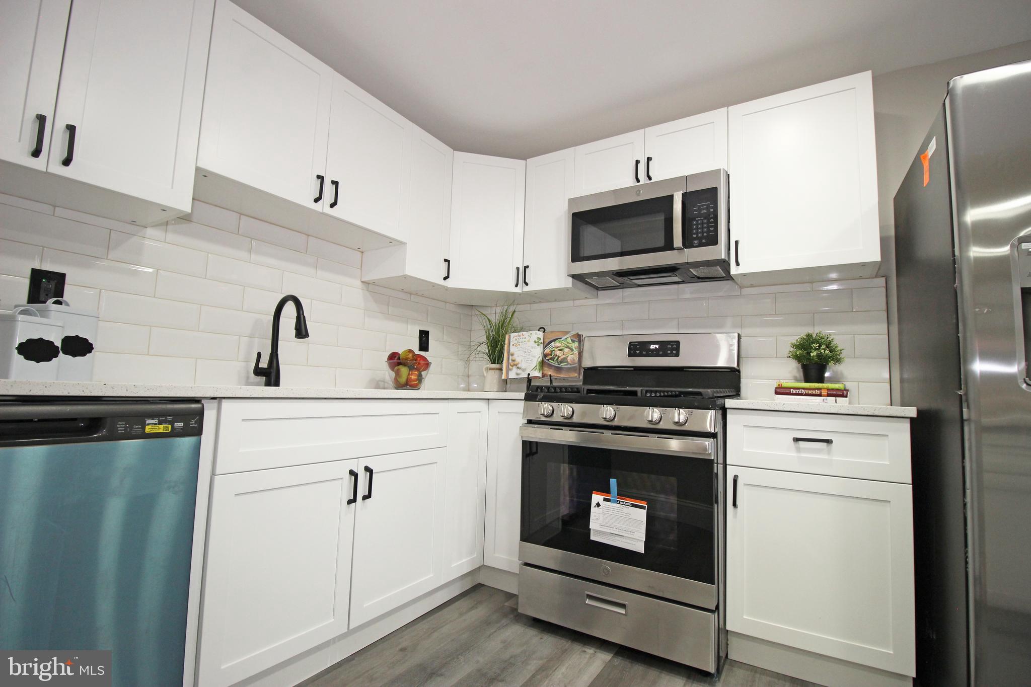 4017 Gideon Road Brookhaven, PA 19015 - Photo 23 of 54 a kitchen with stainless steel appliances white cabinets a stove a sink and a microwave