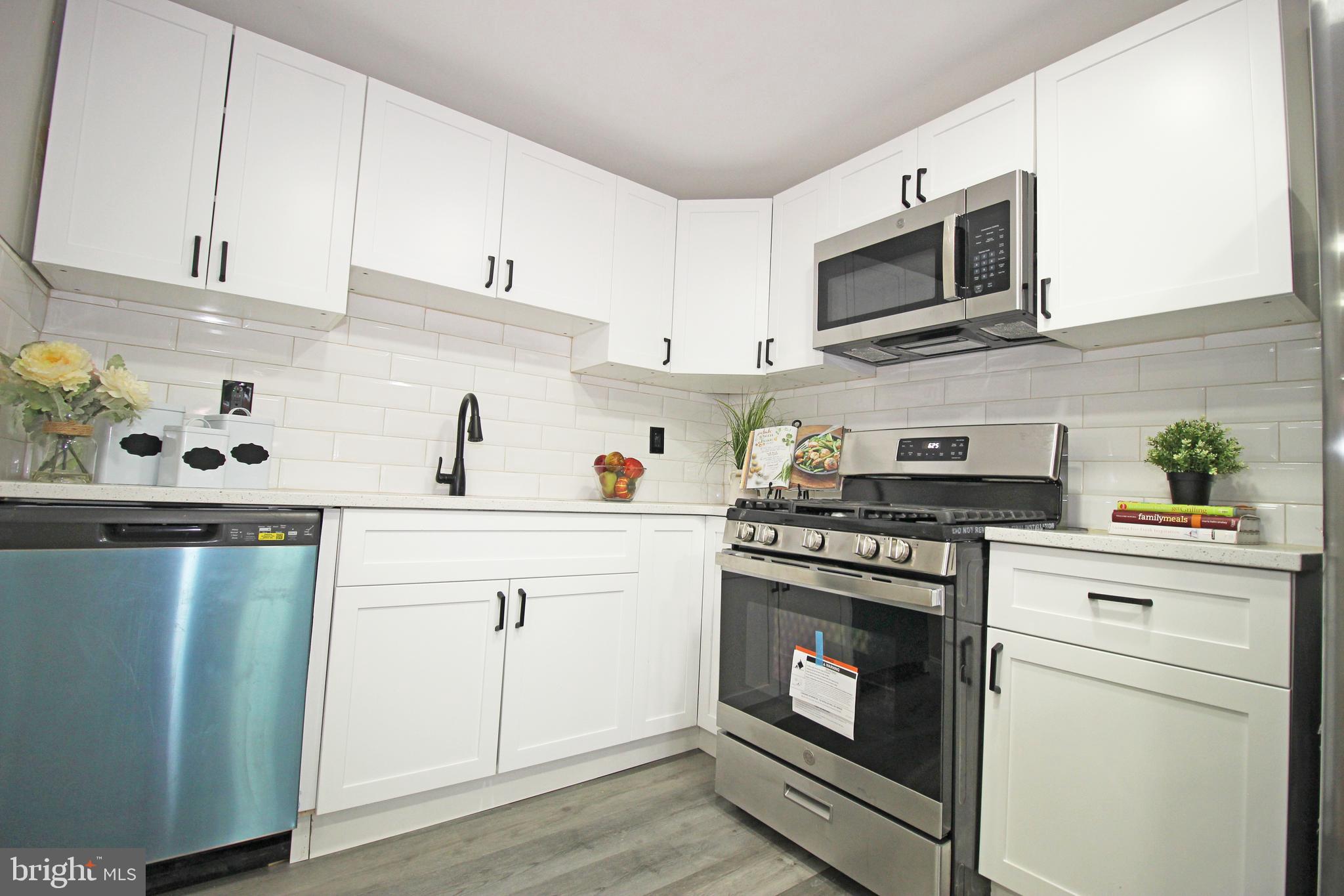4017 Gideon Road Brookhaven, PA 19015 - Photo 25 of 54 a kitchen with cabinets stainless steel appliances and wooden floor