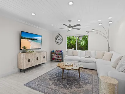 a living room with furniture a window and a flat screen tv