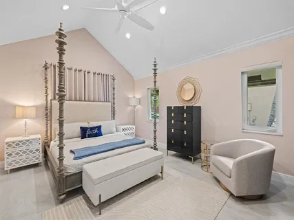 a spacious bedroom with a bed a couch and a chandelier