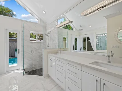 a spacious bathroom with a granite countertop sink a mirror and shower