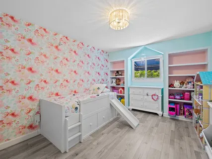 a view of a bedroom with baby bed and a window