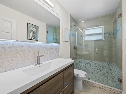 a bathroom with a sink a toilet and shower