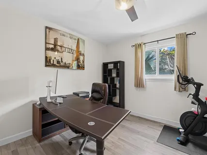 a view of a workspace with furniture and a window