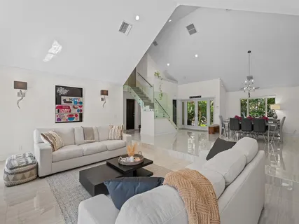 a living room with furniture kitchen view and a potted plant