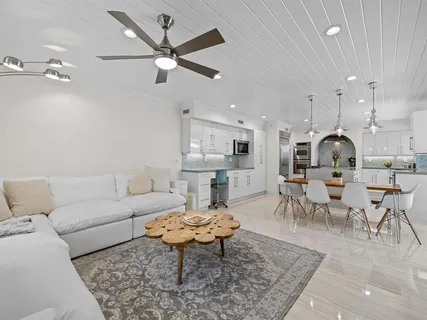 a living room with lots of furniture and a view of kitchen