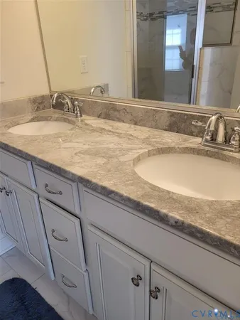 a bathroom with a granite countertop sink and toilet