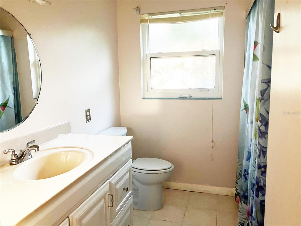 1221 12th Court Southwest Largo, FL 33770 - Photo 7 of 13 a bathroom with a sink toilet and a mirror