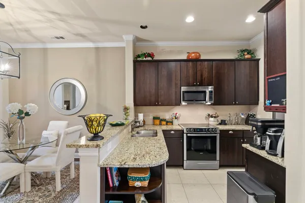 a large kitchen with stainless steel appliances granite countertop a stove a sink dishwasher and a microwave with wooden floor