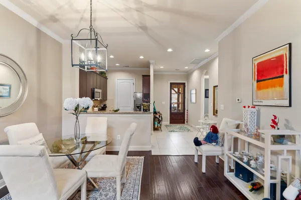 a view of a dining room and livingroom with furniture wooden floor a chandelier