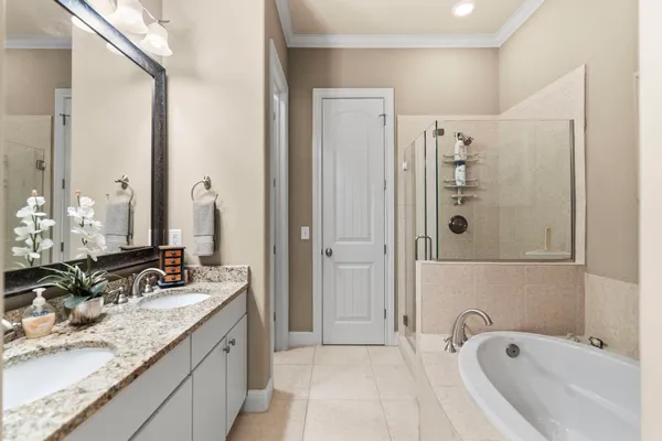 a bathroom with a granite countertop tub sink and mirror