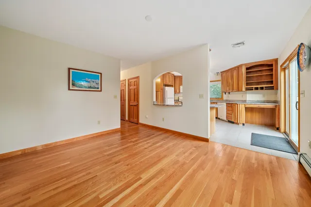 a view of a kitchen with wooden floor and a ceiling fan