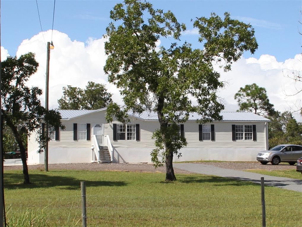 13127 Star Road Brooksville, FL 34613 - Photo 1 of 54 a front view of a house with a yard table and chairs