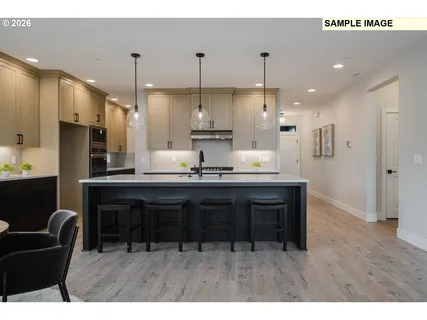 a kitchen with kitchen island granite countertop a sink cabinets and stainless steel appliances