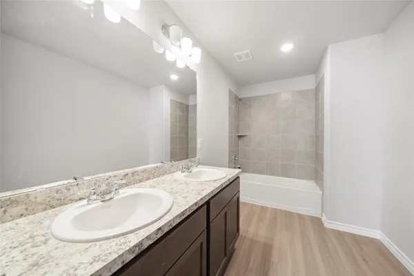 a bathroom with a granite countertop sink a mirror and a bathtub