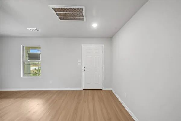 an empty room with wooden floor and a window