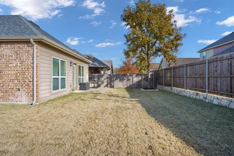 a view of a backyard with wooden fence
