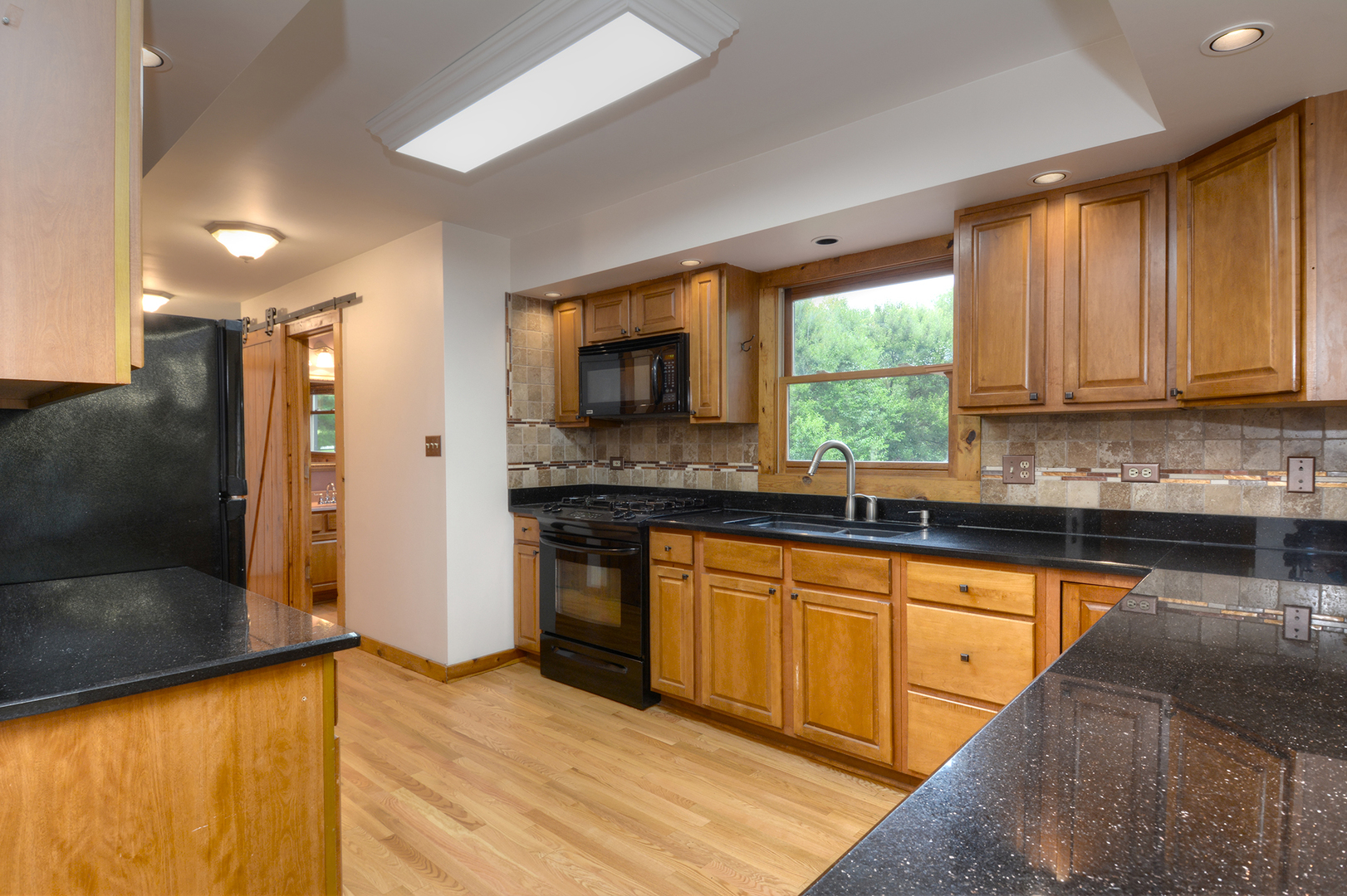 44W290 Plank Road Hampshire, IL 60140 - Photo 9 of 31 a kitchen with stainless steel appliances granite countertop a stove a sink and a microwave